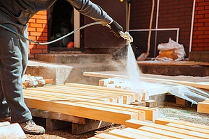 a contractor painting fire treated wood as protection from fire damage